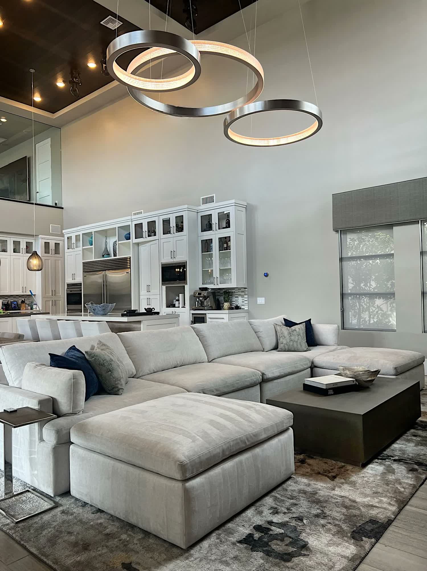 Living room by MIC & NAY with a sectional couch, black coffee table, and contemporary styling